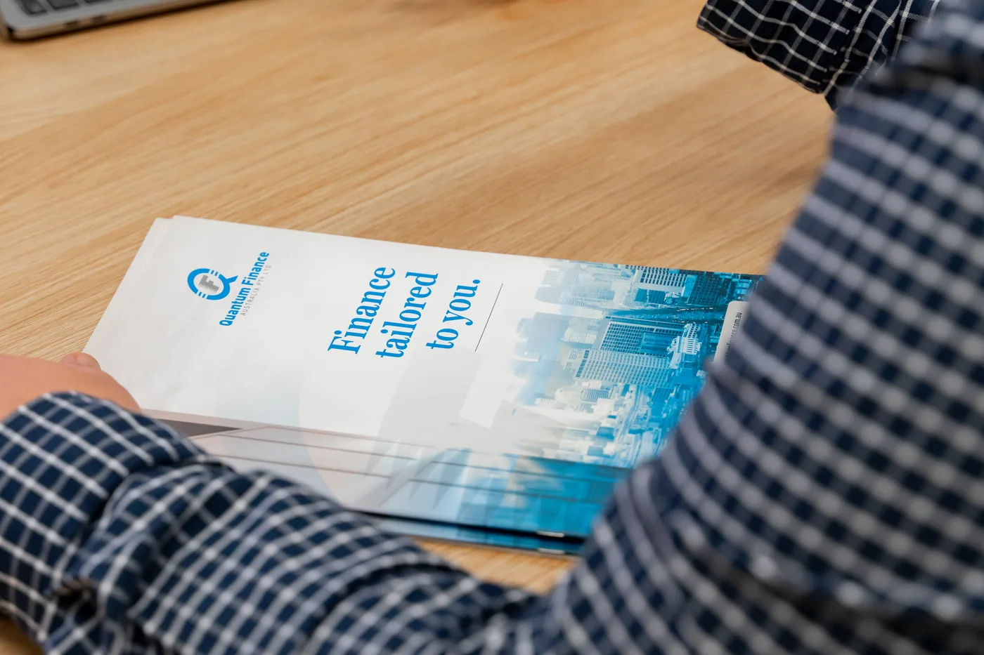 A Quantum Finance borrowing guide open on a broker's desk during a client meeting