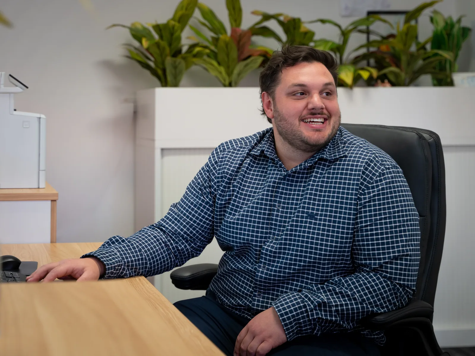 Justin Richardson turned back in his office chair at the desk, laughing, in the open-plan West Leederville office