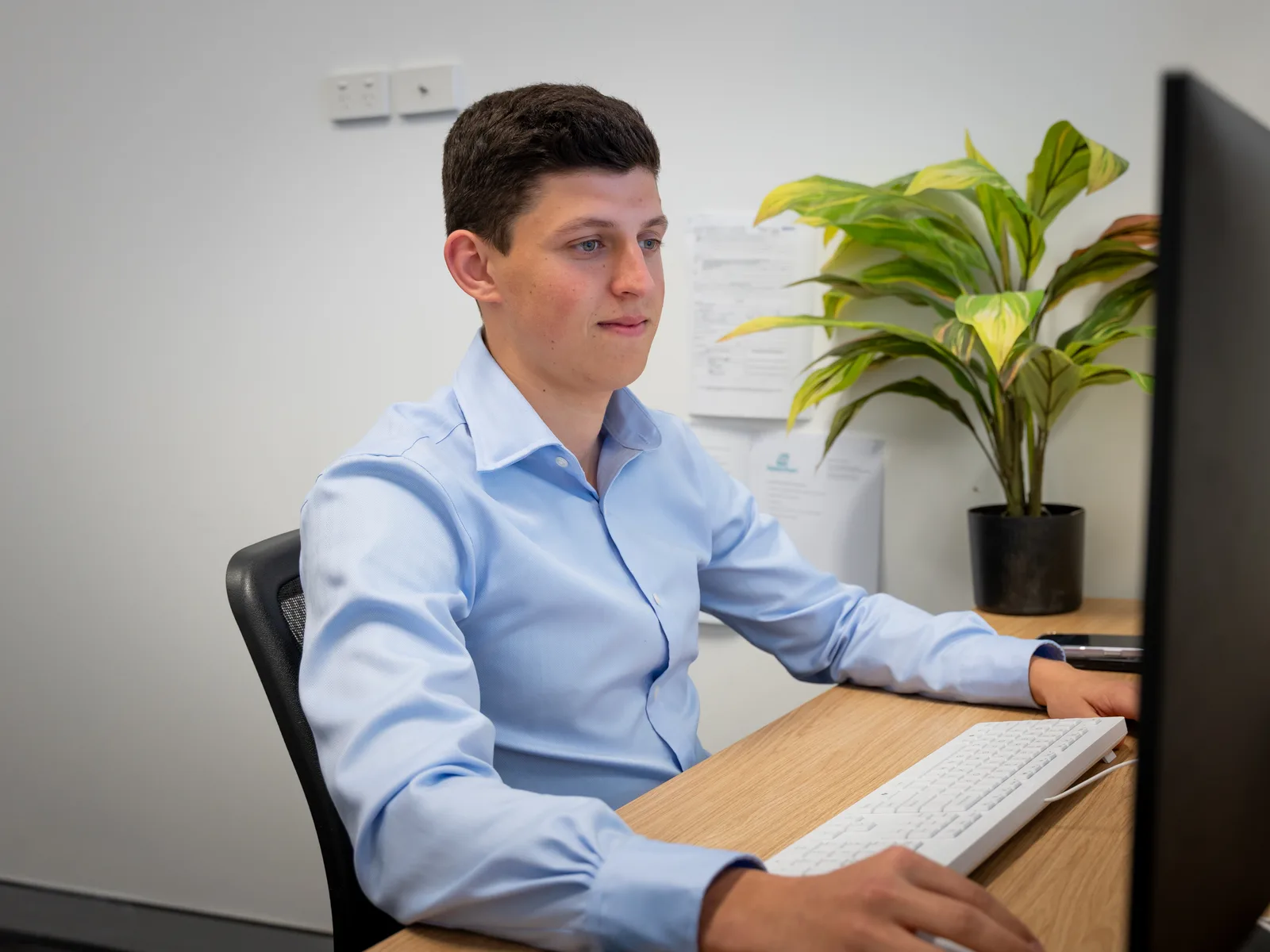 Xavier Prescott working an expat loan file at his desk in the Perth office
